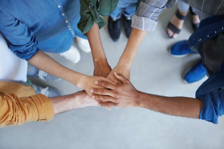 Solidarity and unity conept. Cropped shot of business partners holding their hands together expressi